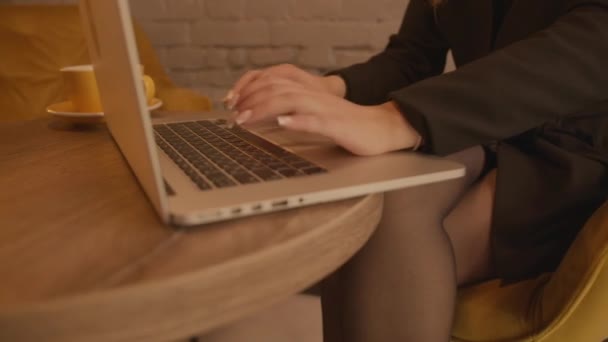 Nahaufnahme einer jungen Frau mit einer schönen Maniküre, die in einem Café auf einem Laptop sitzt — Stockvideo