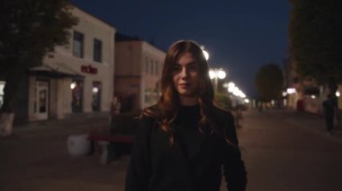 Güzel bir genç kız yanan sokak lambalarının arkasında durdu ve kollarını göğsünün üzerinde kavuşturdu. Yavaş çekim