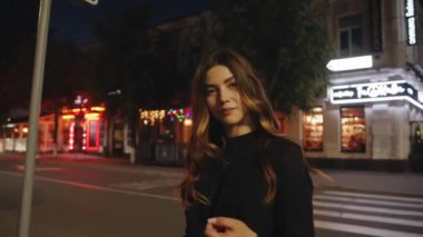 Uzun saçlı, şık siyah elbiseli bir esmer, akşam vakti küçük bir kasabanın tarihi köşelerinde yürür.