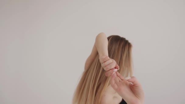En vacker ung flicka är engagerad i stretching i en vit studio och gör mjuka rörelser med händerna. Harmoni och balans — Stockvideo