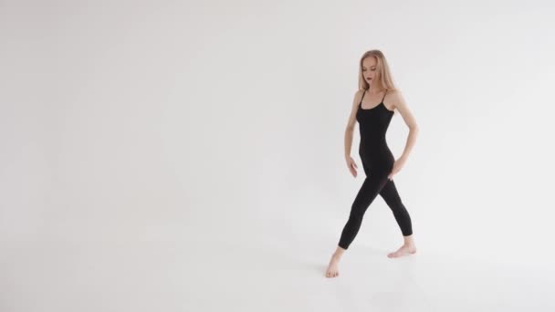 Αισθησιακό κορίτσι που κάνει ένα χορευτικό κίνημα σηκώνοντας το πόδι της κατά τη διάρκεια των μαθημάτων μετά το τέντωμα στο στούντιο. Έννοια αρμονίας και ισορροπίας — Αρχείο Βίντεο