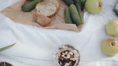 Buğday tarlasında aile pikniği için farklı beslenen beyaz masa örtüsü. Sağlıklı ve sağlıklı gıda konsepti. Yavaş çekim
