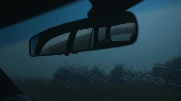 Närbild backspegel och en droppe regn på vindrutan på bilen från insidan — Stockvideo