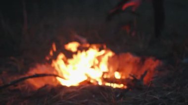 Bir tarladaki çukurda parlak bir şenlik ateşi ve fırlatılan odunların havada kıvılcımları. Yavaş çekim