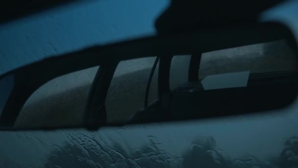 Espejo retrovisor de primer plano y gotas de lluvia en el parabrisas del coche desde el interior — Vídeos de Stock