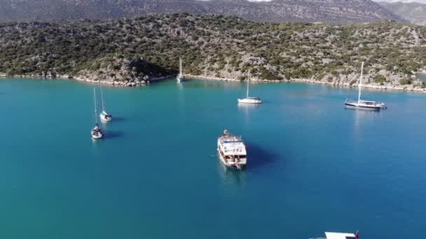 Drohnenaufnahmen der malerischen Natur der türkischen Inseln und der Bucht mit türkisfarbenem Meerwasser mit Segelyachten auf einer Ruhepause — Stockvideo