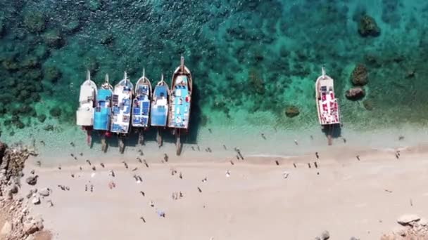Drohnenaufnahmen vom weißen Strand der türkischen Malediven mit vielen Touristen und einer Reihe von Yachten im türkisfarbenen Wasser der Bucht — Stockvideo