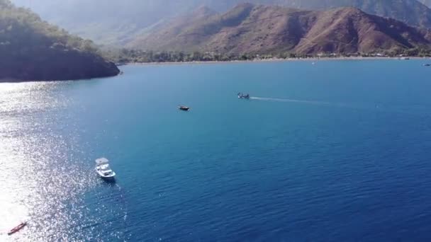 Atemberaubende Luftaufnahme der Bucht des Meeres mit glitzernd blauem Wasser von der Sonne umgeben von Berginseln und Segelyachten mit Touristen — Stockvideo