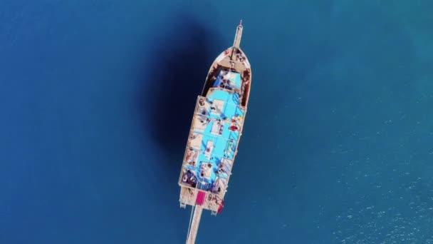 Widok z góry łodzi wycieczkowej z turystami na pokładzie wśród błękitnych, przezroczystych wód morskich — Wideo stockowe
