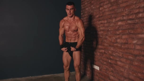Mladý muž v černých trenýrkách ukazuje své svalnaté tělo po intenzivním tréninku a ukazuje palce nahoru oběma rukama a otírá si pot z obličeje — Stock video