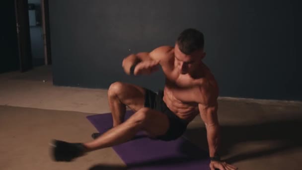 Mladý muž s nahý torza trénink v místnosti a dělá cvičení jumping jack a výpady vpřed — Stock video