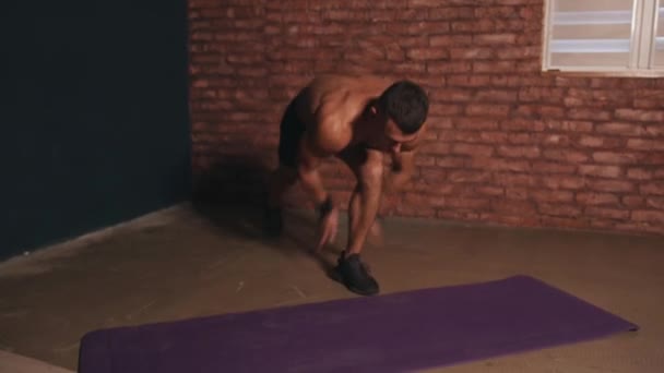 Νεαρός μυώδης άνδρας αποκαθιστά την αναπνοή του μεταξύ σετ καρδιο προπόνηση και αρχίζει push-ups στο χαλί — Αρχείο Βίντεο
