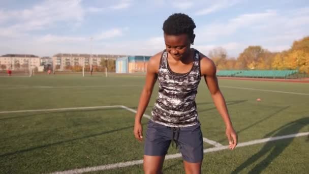 市スタジアムでの若い黒人女子サッカー選手のトレーニングやボールでドリブル運動をしています。動機と成功の概念 — ストック動画