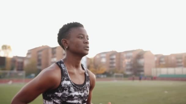 Jovem negra séria correndo na esteira do estádio da cidade durante o treinamento para a equipe de futebol. Movimento lento — Vídeo de Stock