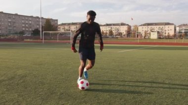 Genç siyahi bir kız stadyumda antrenman yapıyor ve futbol topuyla salya akıtıp ayağına basıyor. Yavaş çekim