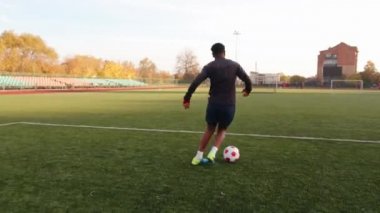 Genç siyahi bir kız stadyumda antrenman yapıyor ve futbol topuyla salya akıtıp ayağına basıyor. Yavaş çekim