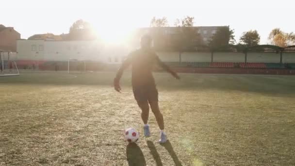 Futbol antrenmanındaki genç siyah kız hareket halinde top tutuşu egzersizi yapıyor ve taktik manevralar yapıyor. — Stok video