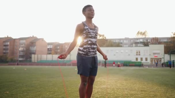 Geconcentreerde Afro-Amerikaanse jonge meisje gaat naar binnen voor sport in het stadion en springtouw. Langzame beweging — Stockvideo