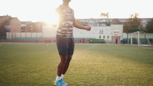 Jovem afro-americana concentrada entra para esportes no estádio da cidade e pulando corda. Movimento lento — Vídeo de Stock