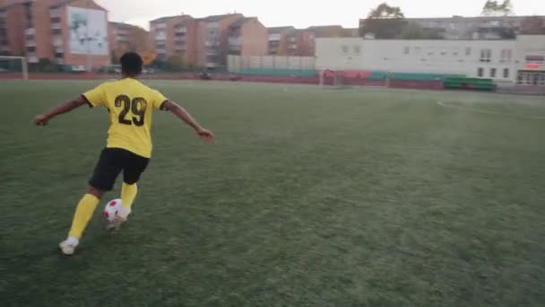 Belarus, Minsk - 20 Haziran 2021: Sarı futbol formalı ve siyah şortlu genç bir kız sahada oynamadan önce top sürme ve hile yapma alıştırması yapıyor. — Stok video