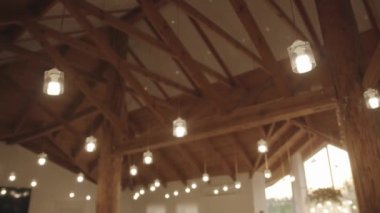 Büyük bir salonda orijinal ahşap tavan manzarası. Bir sürü zemin kirişi ve orijinal cam lambalar var. Yavaş çekim