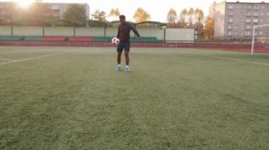 Şehir stadyumunda antrenman yapan genç bir zenci kız futbol topuyla hokkabazlık yapıyor ve ayağına basıyor. Yavaş çekim