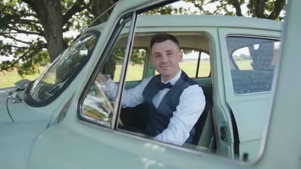 Зблизька руки одруженого чоловіка в білій сорочці і живіт водіння старовинної машини через вітрове скло. — стокове відео