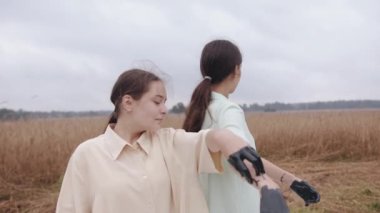 Siyah boyalı ellerle buğday tarlasında dans eden ve gösteri yaparken kıyafetlerini lekeleyen genç kızlar. Tehlike ve endişe kavramı