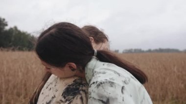 İki genç kız doğada alternatif danslar sergiliyor ve ellerini zarif bir şekilde siyah boyayla kaplıyorlar.