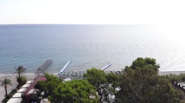 Yüzen plastik rıhtımlarla ve turistlerle dolu güneş panjurlarıyla güneşin sonsuz sakin denizinin havadan görünüşü.
