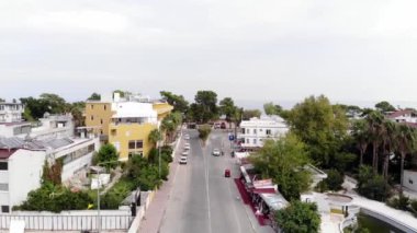 Park halindeki arabaların ve deniz kıyısındaki palmiye ağaçlarının arasında güzel kulübelerin olduğu şehir yolunun en üst manzarası.
