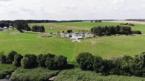 Vista aérea da casa de campo com anexos no campo junto ao rio e encantadora paisagem de verão — Vídeo de Stock