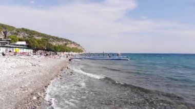 Plajda turistlerle ve denizdeki plastik dubalarla tatil köyünün dağ kıyısında insansız hava araçları vuruldu.