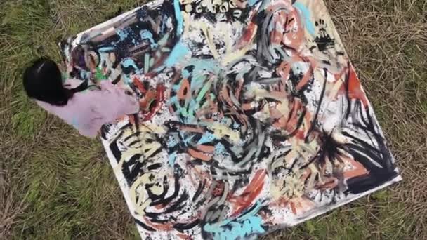 Top view of young girls participating in an alternative performance in nature and painting pictures on canvases — Stockvideo