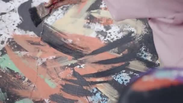 Un artista creativo disegna un quadro astratto su una grande tela e delinea i punti e gli spruzzi con vernice nera. Arte e talento concetto — Video Stock