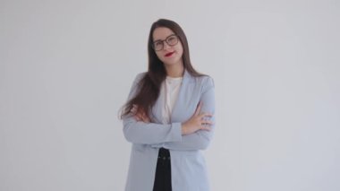 Kendine güvenen genç iş kadını kollarını göğsünün üzerinde beyaz izole bir arka planda kavuşturur. Kariyer ve başarı kavramı. Kadın gücü. feminizm