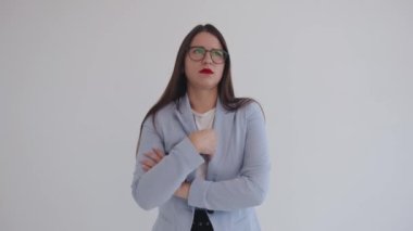Güzel genç bir kız açık mavi ceketini düzeltiyor ve dudaklarını göğsünde çaprazlayarak kesiyor.