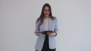 Kendine güvenen genç iş kadını izole edilmiş beyaz bir arka plana karşı duruyor ve elinde bir pano tutuyor. Kariyer ve başarı kavramı