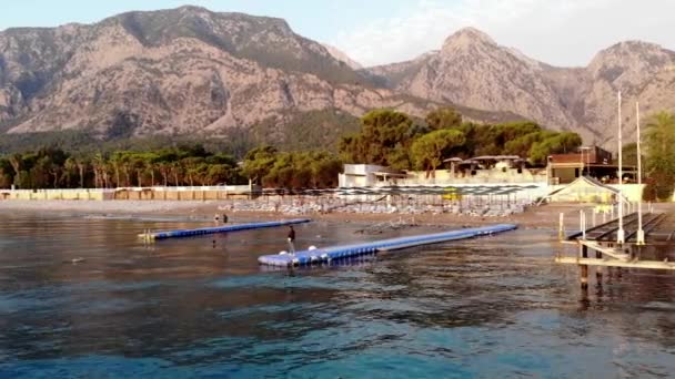 Shooting from drone of a young girl stands on a plastic modular pontoon among the waves of the sea. Contemplation and reflection concept — 图库视频影像