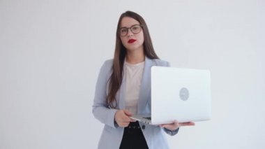 Siyah gözlüklü muhteşem genç bir iş kadınının portresi dizüstü bilgisayarı ile izole edilmiş beyaz bir arka planda duruyor.