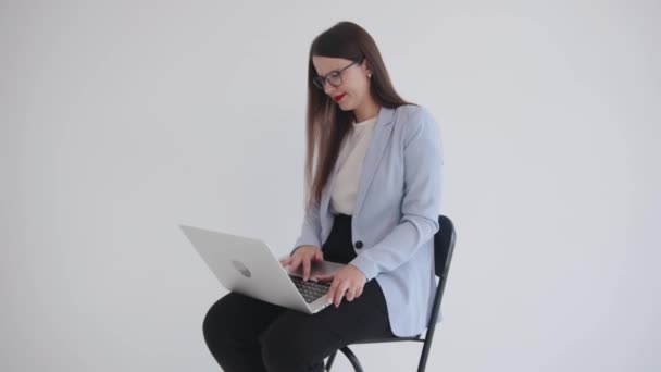 Молодая деловая женщина возмущена проблемой с ноутбуком и сердито нажимает клавиши клавиатуры — стоковое видео