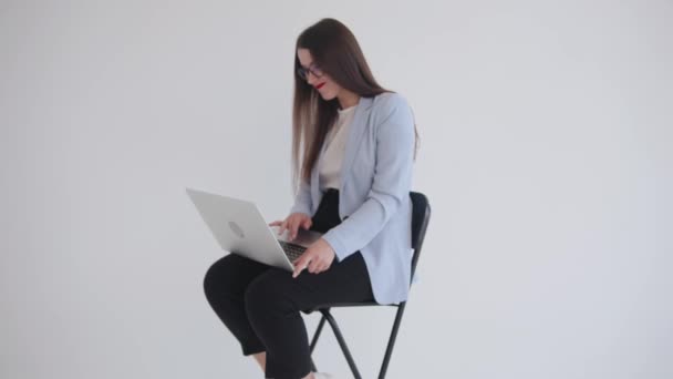 Encantadora jovem mulher de negócios em óculos pretos pressiona a barra de espaço em um laptop e gestos que a página não está carregando — Vídeo de Stock