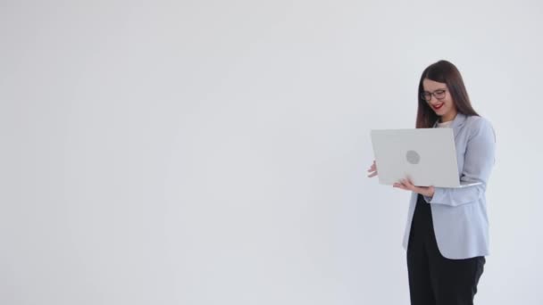 Una giovane donna d'affari brillante è in piedi con un computer portatile in mano e parlando ridendo. Leadership e concetto di successo. Copia spazio — Video Stock
