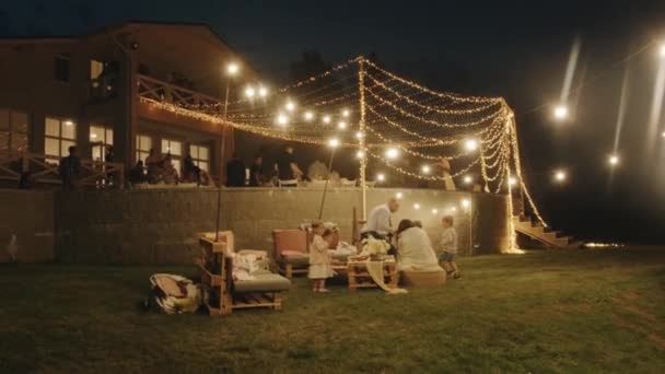 Belarus. MinskAugust 21, 2021: Parents entertain children in the recreation area near the terrace where the wedding party takes place — стокове відео