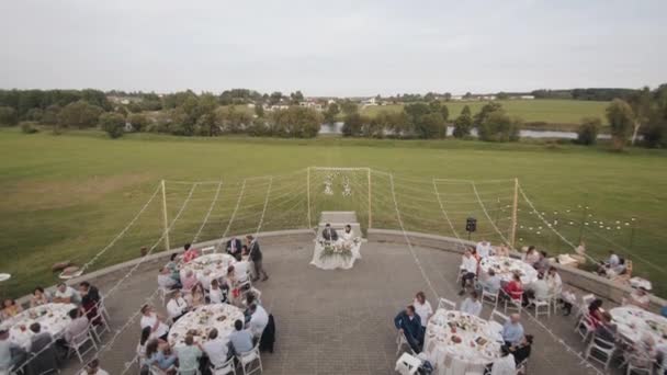 Vitryssland. Minsk21 augusti 2021: Flygfoto över en terrass med nygifta och gäster sittande vid bord under en festlig middag för att hedra bröllopet — Stockvideo