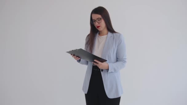 Beautiful young business woman holding documents in her hands and gesturing indignantly with her hand. Career. Femenism. — Stock Video