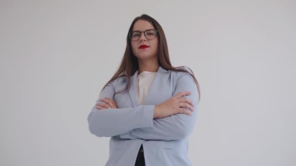 La joven empresaria confiada tiene los brazos cruzados sobre su pecho y se ve altivamente sonriendo y diciendo algo. Poder de mujer — Vídeos de Stock