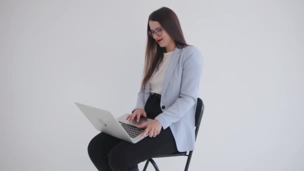 A successful young business lady sits on her lap with a laptop and laughs contagiously. Strong and independent woman concept — 图库视频影像