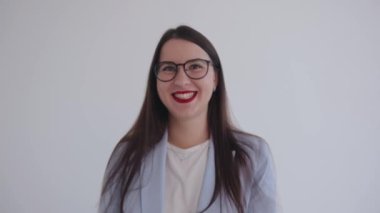 Gözlüklü başarılı genç iş kadını gülüyor ve el hareketi yapıyor. Liderlik ve başarı kavramı. Feminizm. Kadınların gücü