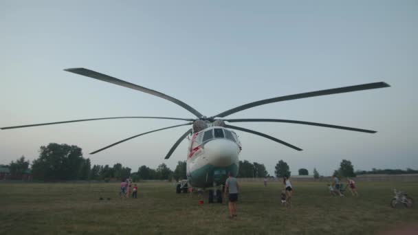 Minsk, Belarus - June 29, 2021: Families with children goes around and inspect helicopter of the Ministry of Emergency Situations — Stock Video